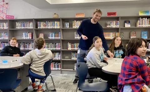 A UNE professor interacts with middle schoolers from Saco at Maine Bioscience Day